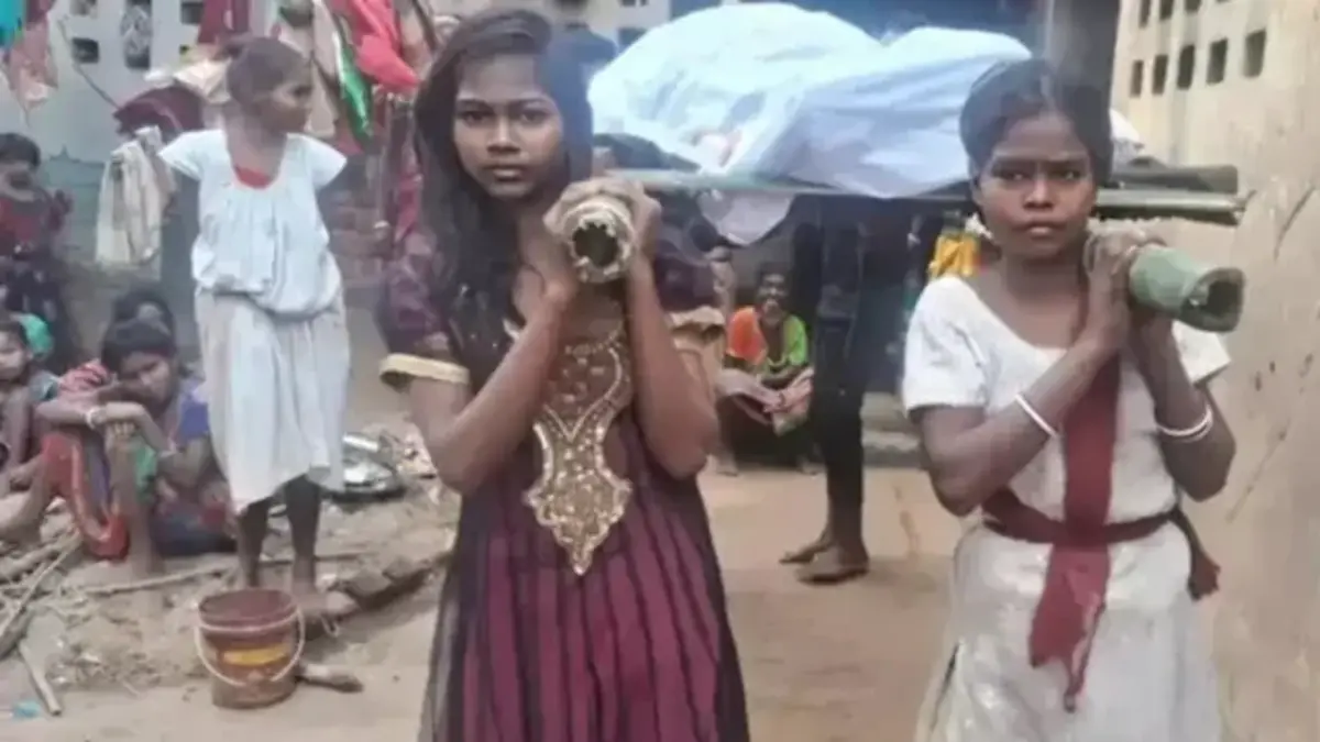 Tribal girl standing near funeral pyre in Jharkhand village - symbol of migration crisis